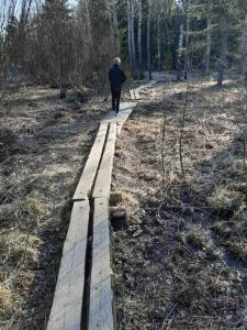 un hombre caminando por un camino de madera en el bosque en ONLY for during Ironman 70.3 3 room and kitchen, en Lahti