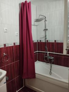 a bathroom with a red shower curtain next to a tub at Dana in Trnava