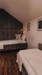 two beds in a small room with wooden floors at Rozewie Apart in Jastrzębia Góra