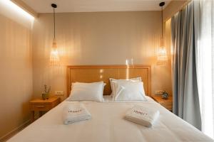ein Schlafzimmer mit einem Bett mit zwei weißen Kissen in der Unterkunft Trinity Design Suites in Valanidorachi