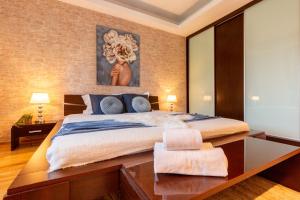 een slaapkamer met een groot bed en een houten tafel bij 1BR Apt with Jacuzzi near Herastrau: Ideal Getaway in Boekarest