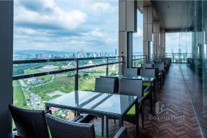 a balcony with tables and chairs and a view of a city at Dorsett Residences Sri Hartamas (Kuala Lumpur) in Kuala Lumpur