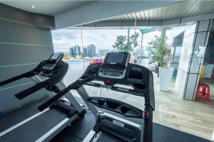 een fitnessruimte met een loopband en een groot raam bij Dorsett Residences Sri Hartamas (Kuala Lumpur) in Kuala Lumpur