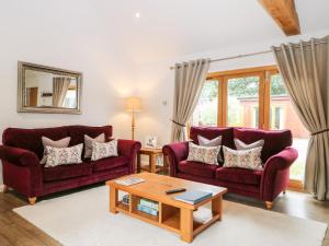 a living room with two purple couches and a coffee table at Squirrels Drey in Fareham