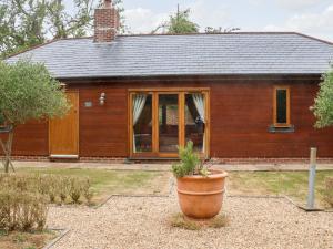 a wooden house with a large pot in front of it at Squirrels Drey in Fareham