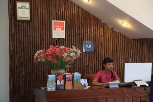 a man sitting at a desk in a cash register at The Earth Villa in Hoi An