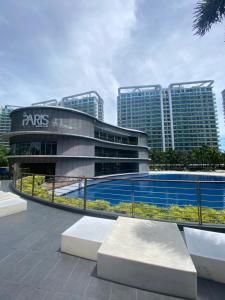 un edificio con una piscina frente a él con edificios altos en Marshall’s Place Azure Staycation, en Manila