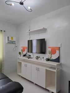 ein Wohnzimmer mit einem Flachbildfernseher an der Wand in der Unterkunft Camella Manor Majorca in Bacolod City