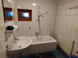 Ferienhaus Kirchler في هيباخ: حمام مع حوض ومغسلة ودش