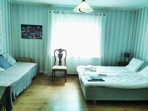 - une chambre avec deux lits, une chaise et une fenêtre dans l'établissement Hus Näckrosen, à Ruda