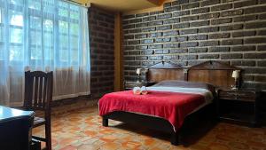 a bedroom with a bed and a brick wall at Hermosa Cabaña en la Naturaleza in Huitzilac