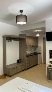 uma grande cozinha com armários de madeira e uma parede branca em Emerald Suites em Vryses