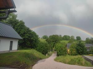 a rainbow over a house and a road at Na Kopečku apartmány in Cerny Dul