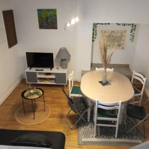 een woonkamer met een tafel en een tafel en stoelen bij Gîte le Rouge Gorge de Brocéliande in Beignon