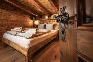 1 dormitorio con 1 cama en una cabaña de madera en Alpin-Chalet in Alleinlage in Bad Ischl - Wald, Natur, Kamin & Sauna en Bad Ischl