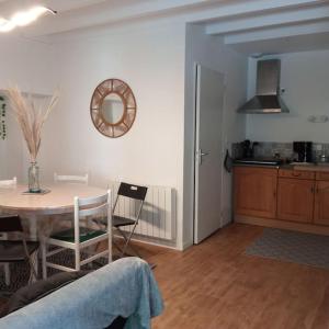 a kitchen and dining room with a table and a table and chairs at Gîte le Rouge Gorge de Brocéliande in Beignon