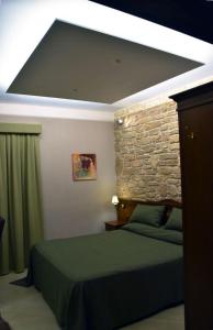 1 dormitorio con cama y pared de piedra en Hotel Vogue, en Licola