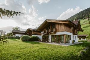 a house in the mountains with a green lawn at Ferien und Familienhaus Robert Haider in Innervillgraten