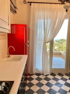 a kitchen with a red refrigerator and a window at ST NIKOLA PANORAMIC SUITES HALKIDIKI in Agios Nikolaos