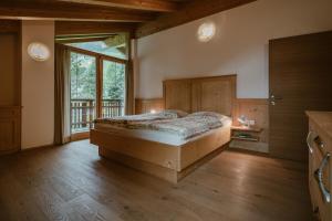 um quarto com uma cama e uma grande janela em Ferien und Familienhaus Robert Haider em Innervillgraten