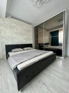 a bedroom with a large bed and a large mirror at Apusului Residence Modern 2 Bedroom Apartment in Roşu