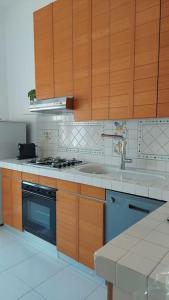 una cucina con mobili in legno, una stufa e un lavandino di Giulia Town House tra città e mare a Salerno