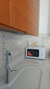 a kitchen with a sink and a microwave at Giulia Town House tra città e mare in Salerno