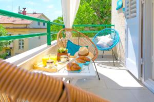 a table with breakfast food on a balcony at LUXE SPLIT Beach COLLECTION in Split