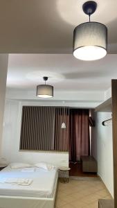 a bedroom with a bed and two lights on the ceiling at Emerald Suites in Vryses +1 photo