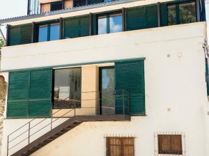 a building with green shutters on the side of it at Casa rural fuente de la mora in Uña +3 photos