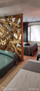 1 dormitorio con 2 camas y pared de madera en La Impronta Relax en Lleida