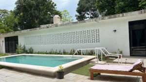 a swimming pool in a yard with a bench and a house at King's Tuuch Bacalar - Cerca de la Laguna in Bacalar