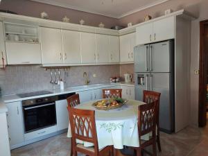 eine Küche mit einem Tisch und einer Obstschale darauf in der Unterkunft Olympos Philoxenia, μεταξύ βουνού και θάλασσας in Kateríni