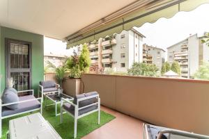 Apartament z balkonem z krzesłami i widokiem na budynki w obiekcie Oasis Luxury - A.C/Terrace/2Bedrooms w Bergamo