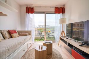 a living room with a couch and a large window at diamant in Choisy-le-Roi
