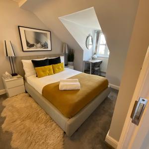 1 dormitorio con 1 cama grande con almohadas amarillas en Home away from home, en Londres