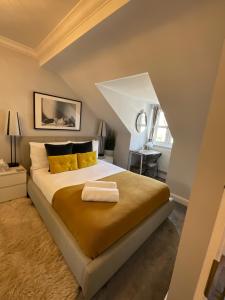 a bedroom with a large bed with yellow pillows at Home away from home in London