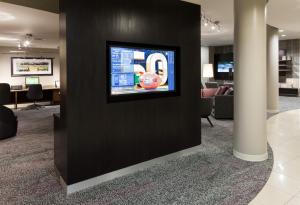 einen Fernseher an einer Wand in einer Bürolobby in der Unterkunft Courtyard by Marriott Miami at Dolphin Mall in Miami