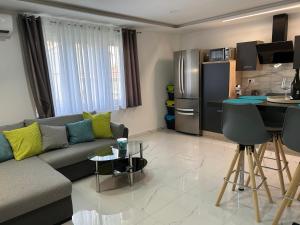 a living room with a couch and a kitchen at Rijeka UrbanSPA in Rijeka