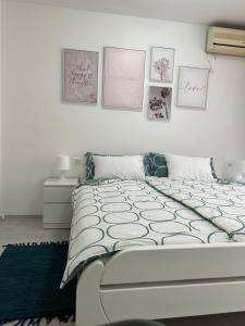 Schlafzimmer mit einem Bett mit Bildern an der Wand in der Unterkunft Rijeka UrbanSPA in Rijeka