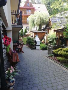 a walkway in a yard with benches and flowers at Willa Marianna in Zakopane