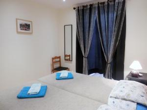 une chambre avec un lit avec des serviettes bleues dessus dans l'établissement Downtown, Cozy Apartment In Lisbon, à Lisbonne