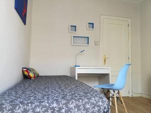 バレンシアにあるMalvarrosa Beachのベッドルーム1室(ベッド1台、デスク、青い椅子付)