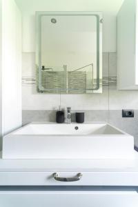 W łazience znajduje się biała umywalka i lustro. w obiekcie Oasis Luxury - A.C/Terrace/2Bedrooms w Bergamo