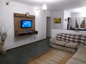a living room with a couch and a flat screen tv at Chacara Vale dos Sonhos Itu in Itu