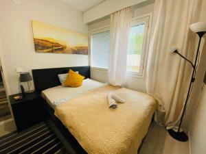 a small bedroom with two beds and a window at Cozy private room with free parking and sauna in Vantaa