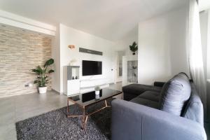 sala de estar con sofá y mesa en Oasis Luxury - A.C/Terrace/2Bedrooms, en Bérgamo