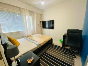 a small room with a bed and a television at Cozy private room with free parking and sauna in Vantaa