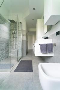 y baño con bañera, lavamanos y ducha. en Oasis Luxury - A.C/Terrace/2Bedrooms, en Bérgamo