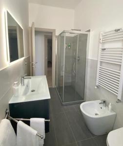 Un baño con lavabo y ducha de cristal. en Titti's House - Parcheggio custodito in garage gratis, en Génova
